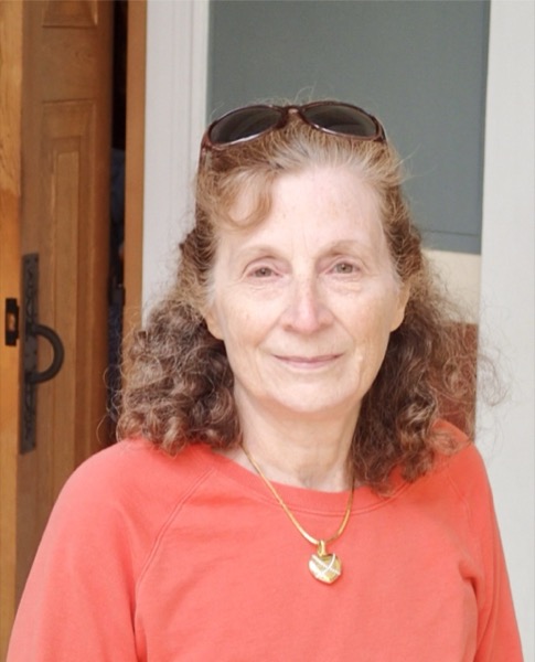 Bess Wray, founder of Human Touch Home Care, wearing an orange shirt and smiling