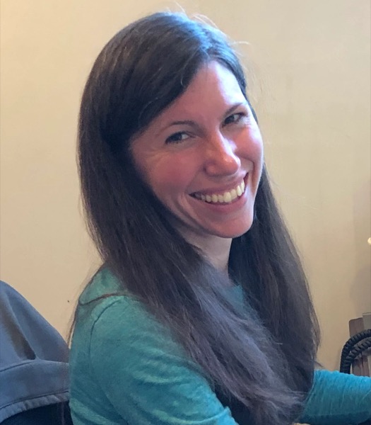 Marie Crosby smiling brightly in a teal top